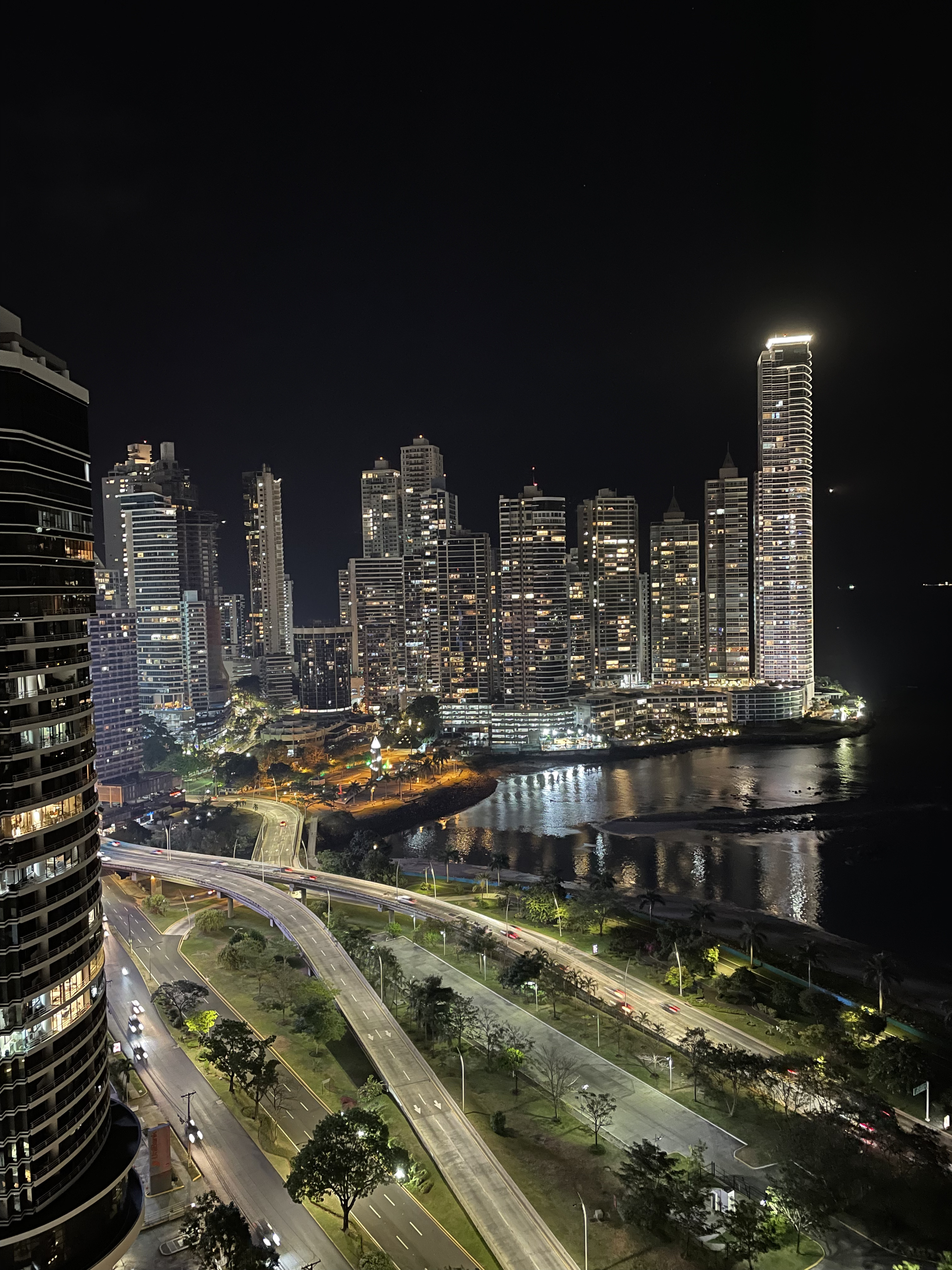 A Panama City residential tower at dusk, seen from a quiet neighborhood street — the kind of view that draws people toward buying before they've asked the harder questions
